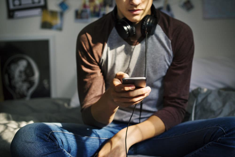 photo: Young man looking at cell phone
